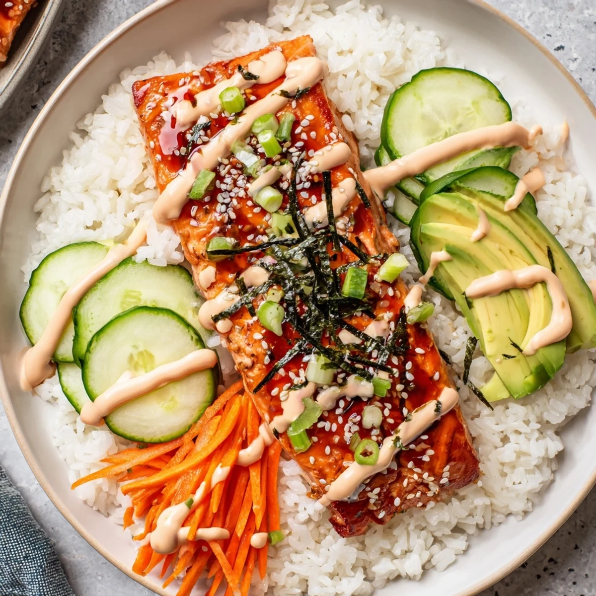 Scrumptious teriyaki salmon rice bowl: seared salmon glistening atop fluffy rice with fresh, colorful toppings.