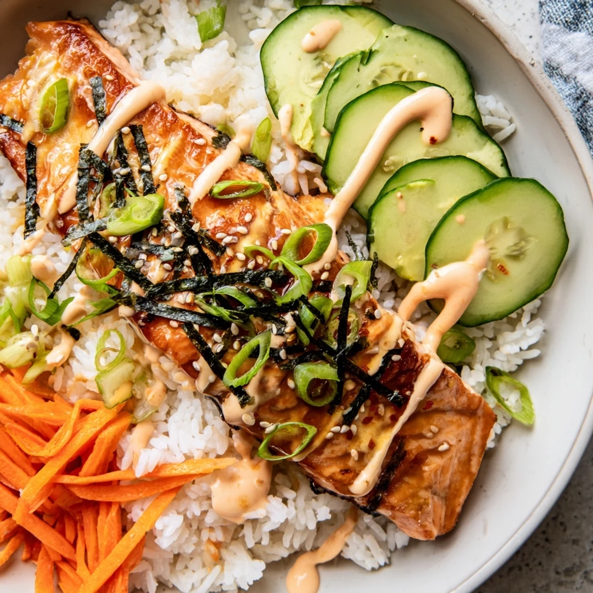 Savory teriyaki salmon rice bowl, featuring perfectly cooked salmon fillets and a creamy sriracha mayo finish.
