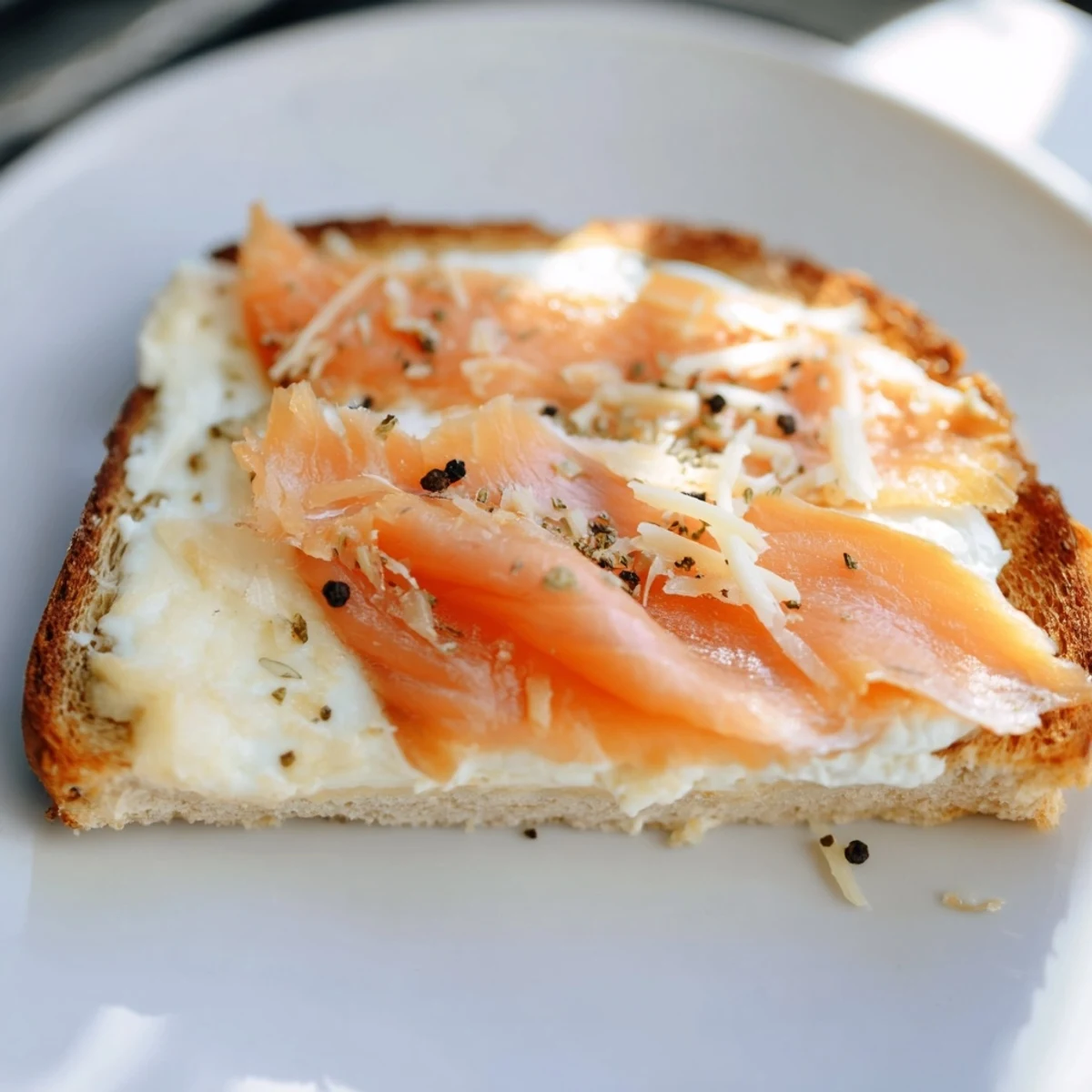 Golden, melty Smoked Salmon Grilled Cheese with flaky salmon and herbs, ready to be cut.
