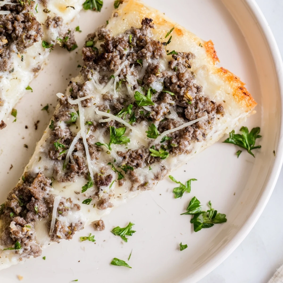 Ground Beef Alfredo Pizza, steaming hot with melted mozzarella and savory ground beef, ready to eat.