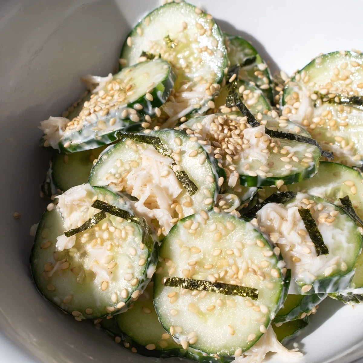 Fresh California Roll Cucumber Salad features crisp cukes, creamy Kewpie mayo, and shredded imitation crab topped with crunchy sesame seeds and nori strips. 