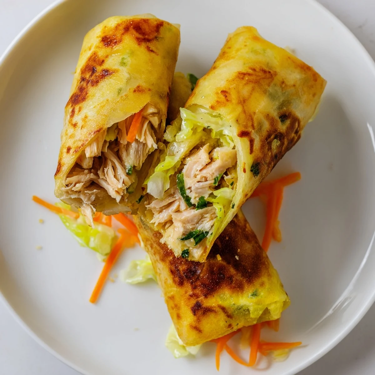 Succulent garlicky pulled chicken tucked inside delicate rice paper wrappers, pan-fried until golden and paired with lemon wedges.  