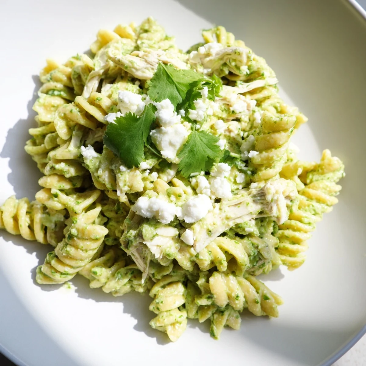 Fresh cilantro lime chicken pasta served warm, rotini and tender chicken tossed in tangy Greek yogurt sauce topped with cheese.