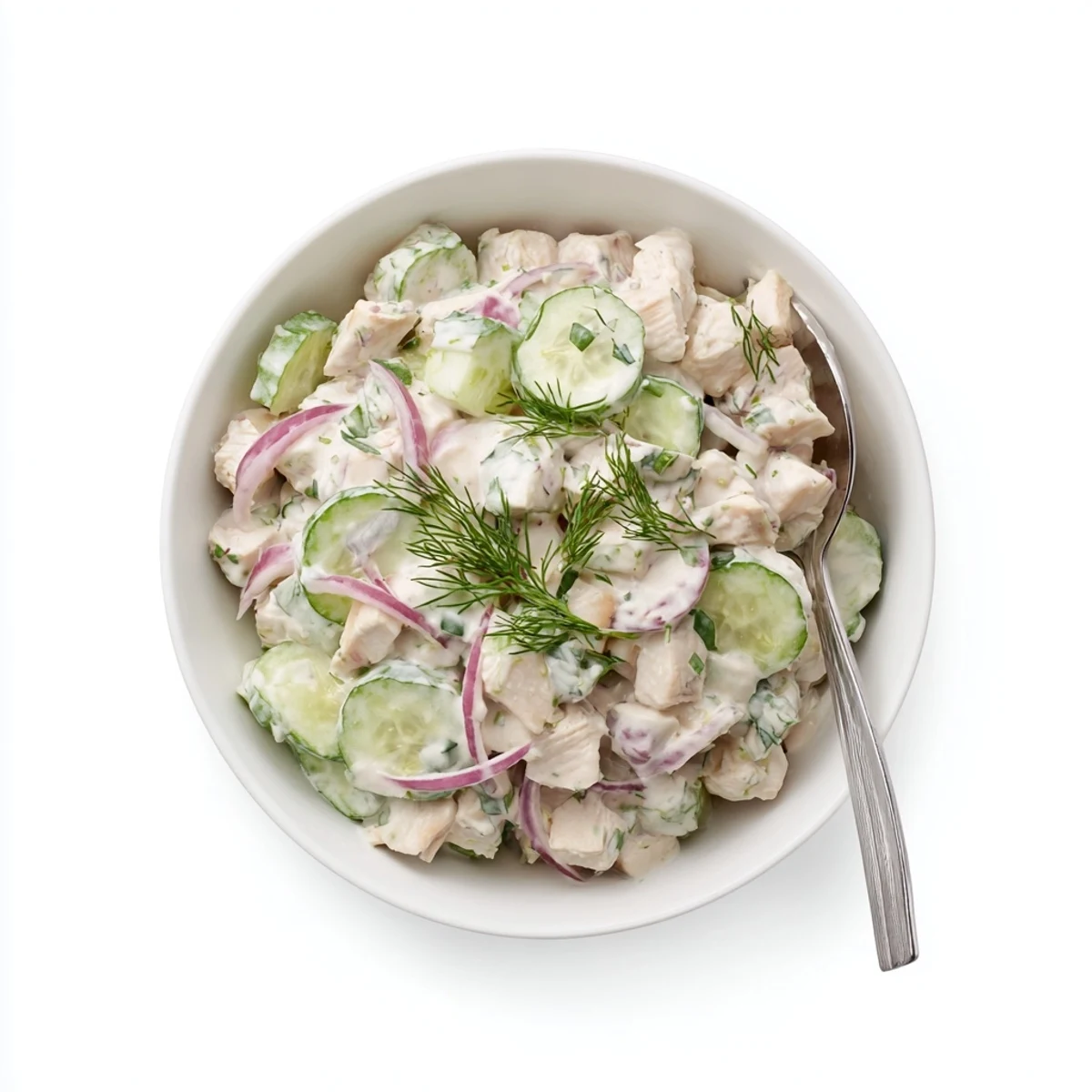Crisp cucumber slices and tender shredded chicken coated in creamy dill yogurt, served chilled in a white bowl.  