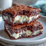 Cream cheese stuffed brownie cookies with gooey centers and fudgy edges, baked to golden perfection.  