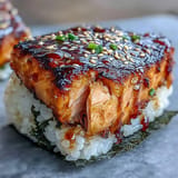 Savory grilled salmon onigiri triangles, offering a warm, flaky, and satisfying bite.