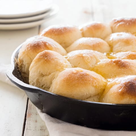 This image shows freshly baked Quick Skillet Cornbread; the golden crust promises a tender crumb, drizzled with honey butter.