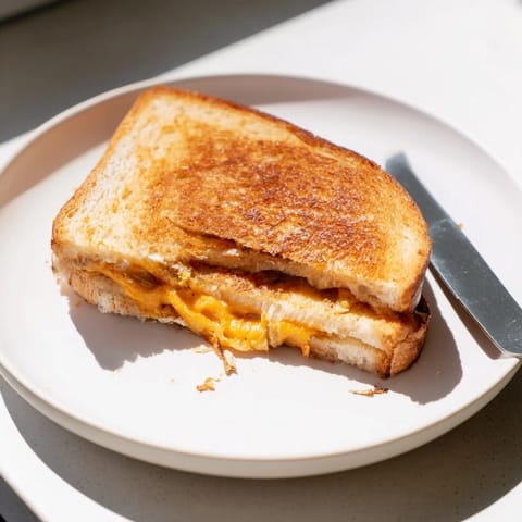 Sliced in half, this homemade Cheddar Jalapeño Grilled Cheese reveals gooey sharp cheddar and tangy peppers.