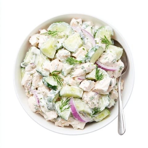 A close-up of Creamy Cucumber Chicken Salad garnished with fresh dill and green onions for a light summer lunch.  