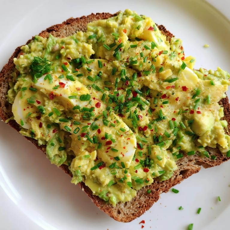 Savory avocado egg smash, garnished with chives, a quick and delicious light lunch idea.