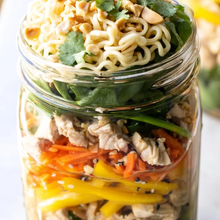 Spicy soy-sesame sauce coats noodles and crisp vegetables, garnished with chopped peanuts and cilantro for a satisfying crunch.