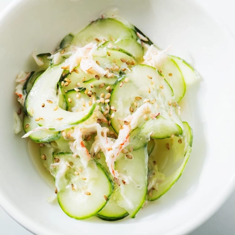 Bright California Roll Cucumber Salad with creamy dressing, crab, and sesame seeds, plated beside chopsticks for an easy, 15-minute appetizer.