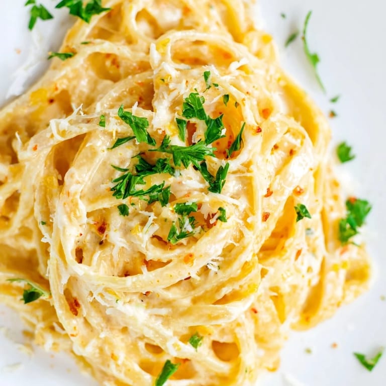 A bowl of Sriracha Honey Pasta topped with parsley and Parmesan, served for dinner.