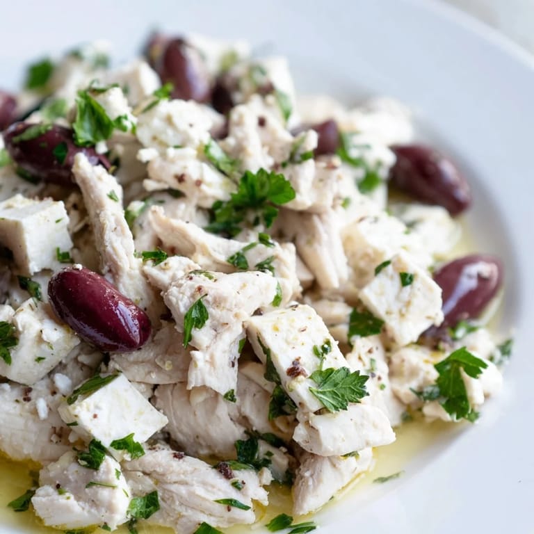 Freshly prepared Mediterranean Chickpea Chicken Salad featuring Kalamata olives, cherry tomatoes, and parsley, served on a light lunch platter.  
