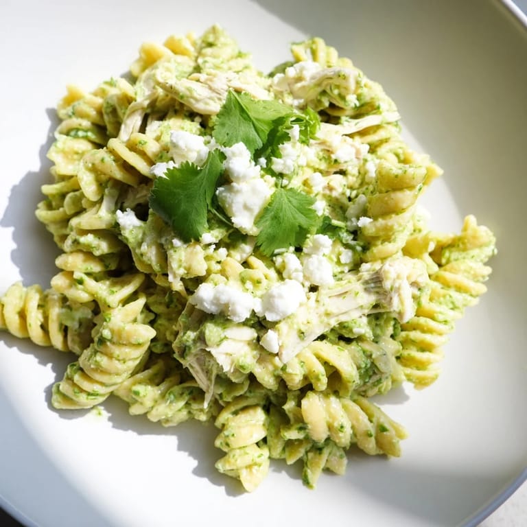 Fresh cilantro lime chicken pasta served warm, rotini and tender chicken tossed in tangy Greek yogurt sauce topped with cheese.