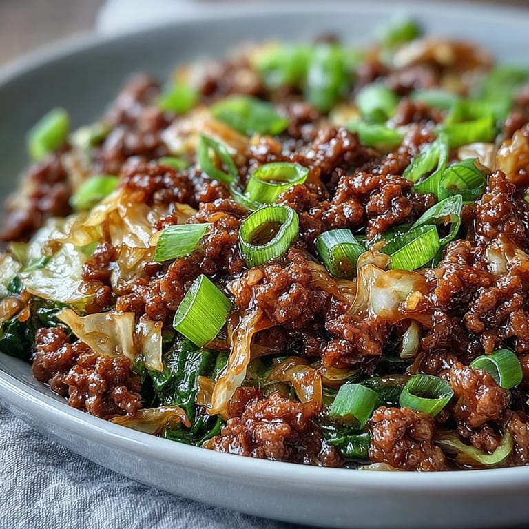 Homemade Chinese Ground Beef and Cabbage Stir-Fry sizzles in a hot wok, coated in glossy savory sauce.