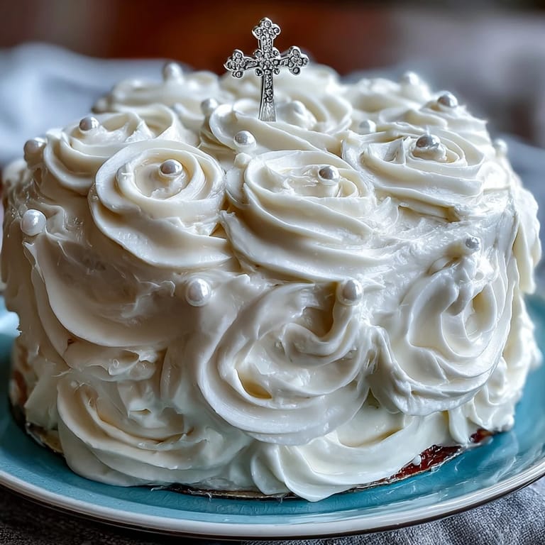 Classic vanilla sponge layered with silky buttercream and adorned with delicate white roses, topped with a cross for First Communion