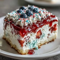 Festive Memorial Day Red White Blue Poke Cake topped with whipped cream and sprinkles.